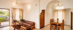 a living room with a couch and a table at Mist & Meadows Premium VIlla By STAYVA in Munnar