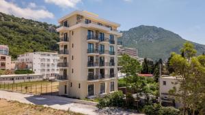 an apartment building with a mountain in the background at Majestic Bay in Čanj