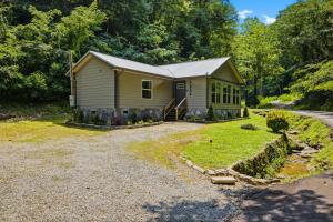 a small yellow house with a gravel driveway at Rustic Retreat — Easy Access, Peaceful Setting, Close to Everything in Sevierville