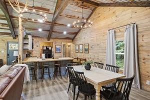 a dining room and kitchen in a log cabin with a table and chairs at Rustic Retreat — Easy Access, Peaceful Setting, Close to Everything in Sevierville