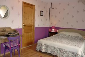 a bedroom with a bed and a table and a mirror at Le Logis Du Mesnil 