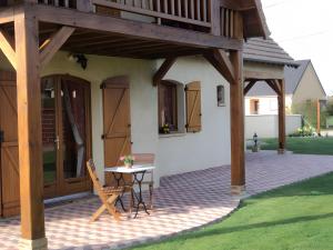 a pavilion with a table and chairs on a patio at Le Logis Du Mesnil 