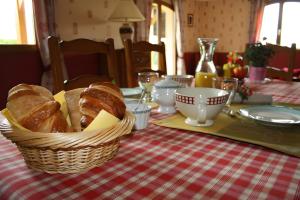 a table with a basket of bread on a table at Le Logis Du Mesnil 