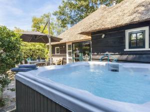 a large swimming pool in front of a house at Hytte in Balkbrug