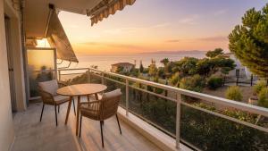 a balcony with a table and chairs and a view of the ocean at Kineta Prime Suites No3 in Kineta