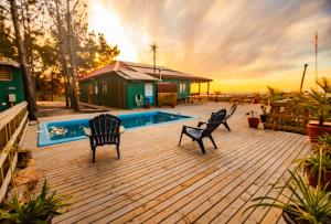 a deck with two chairs and a swimming pool at Cabañas Isla del Mar in Constitución