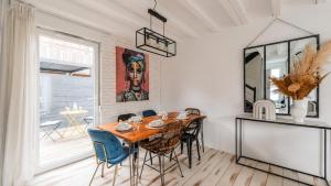 a dining room with a wooden table and chairs at Les clos des Aviateurs in Strasbourg