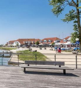 a wooden bench sitting on a pier next to a body of water at Seestern in Rerik