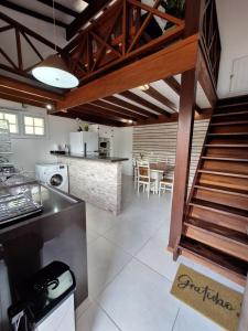 a kitchen with a staircase leading to a dining room at Apartamento em Maresias a 100 metros da praia in Maresias