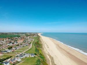 an aerial view of a beach with houses and the ocean at california cliffs caravan 2 dunlin in Scratby