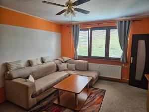 a living room with a couch and a ceiling fan at WOLF APARTMAN Luxusné ubytovanie s plnou výbavou s Bezplatným parkovaním SMART TV a Optickým Internetom Priamo v Považskej Bystrici Tichá lokalita s Všade blízko Vhodné pre Jednotlivcov Rodiny Pracovné cesty Turistiku aj Oddych Plne vybavená Kuchyňa in Považská Bystrica