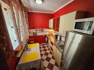 a kitchen with red walls and a stainless steel refrigerator at WOLF APARTMAN Luxusné ubytovanie s plnou výbavou s Bezplatným parkovaním SMART TV a Optickým Internetom Priamo v Považskej Bystrici Tichá lokalita s Všade blízko Vhodné pre Jednotlivcov Rodiny Pracovné cesty Turistiku aj Oddych Plne vybavená Kuchyňa in Považská Bystrica