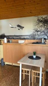 a kitchen with a table and a plane on the wall at Útulné dřevěné chatky Kunovice in Kunowitz +1 photo