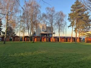 a building in a field with trees and grass at Útulné dřevěné chatky Kunovice in Kunowitz