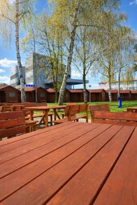 a wooden table with benches and trees in a park at Útulné dřevěné chatky Kunovice in Kunowitz