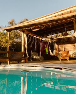 a swimming pool with a pergola and a patio at Glamping Traslasierra Carpa Sur in San Javier