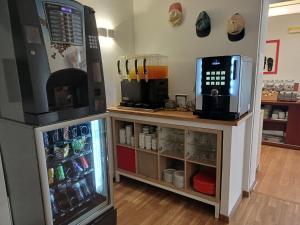 a coffee shop with a refrigerator and a microwave at Hotel Verde Pinho Bed&Breakfast in São Pedro de Moel