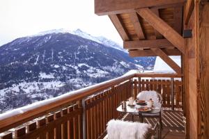 a table on a balcony with a view of a mountain at Dent Blanche Resort - TemptingPlaces Collection in Hérémence