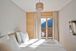 a bedroom with a bed with a large window at Dent Blanche Resort - TemptingPlaces Collection in Hérémence