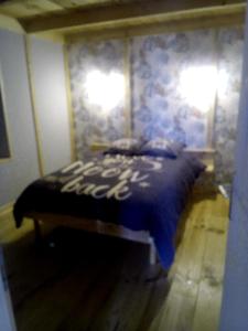 a bedroom with a bed with a blue comforter at Le relais de la mine in Champagnac +4 photos
