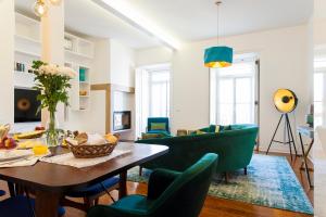a living room with a table and green chairs at Bairro Alto Viewpoint Flat in Lisbon