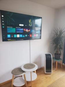 a room with two tables and a tv on a wall at Apartament Klara7 in Herbolzheim