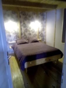 a bedroom with a bed with two lights on the wall at Le relais de la mine in Champagnac