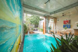 a swimming pool in a house with a painting on the wall at DQ Peaceful Villa in Thôn Dương Xuân Hạ