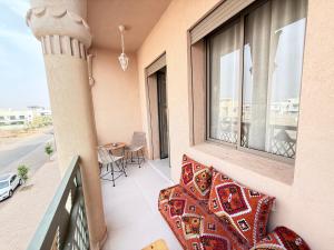 a balcony with a table and chairs and a window at Riad Marrakech, oasis apartment in Marrakesh