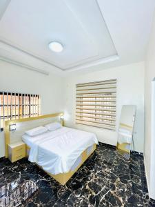 a bedroom with a bed and a window in it at Westtzs Home I in Yaoundé