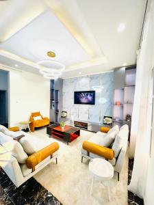 a living room with couches and a tv at Westtzs Home I in Yaoundé +24 photos
