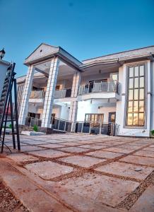 a large white building with a staircase in front of it at Westtzs Home I in Yaoundé