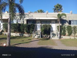 a house with a palm tree in front of it at Suits Recanto do Sabiá in Brotas