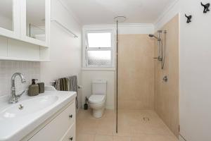 a bathroom with a toilet and a sink and a shower at The Palms in Redcliffe +35 photos