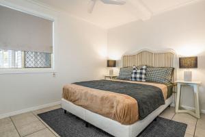 a bedroom with a large bed and a window at The Palms in Redcliffe