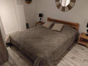 a bedroom with a large bed with two pillows at Villette à Mollans chez Aude & Yo in Mollans-sur-Ouvèze
