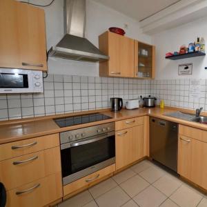 a kitchen with wooden cabinets and a stove top oven at Comfortable Private Room in a Prime Location! HBF in Wolfsburg