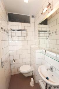a white bathroom with a toilet and a sink at Comfortable Private Room in a Prime Location! HBF in Wolfsburg +3 photos