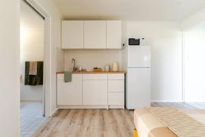 a kitchen with white cabinets and a white refrigerator at Margate Beach Studio 3 in Redcliffe