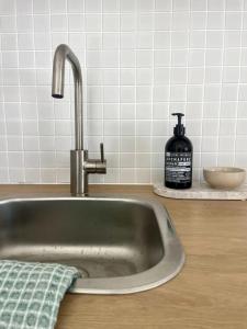 a sink with a bottle of soap on a counter at Margate Beach Studio 3 in Redcliffe