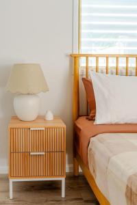 a lamp on a night stand next to a bed at Margate Beach Studio 3 in Redcliffe