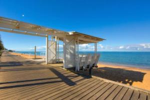 a wooden boardwalk with a bench on the beach at Margate Beach Studio 3 in Redcliffe +17 photos