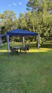 a picnic table and chairs under a blue canopy at Ranchen B&B in Enköping