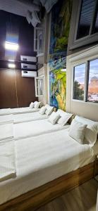 a row of white beds in a room at Centre Cheap Hotel in Tashkent +178 photos