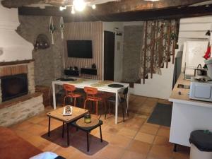 a kitchen with a table and chairs in a room at Villette à Mollans chez Aude & Yo in Mollans-sur-Ouvèze