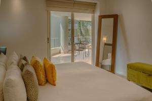 a bedroom with a bed with pillows and a balcony at NITTA 209 Elegant Apartment - Partial Sea Views in Nuevo Nayarit +19 photos