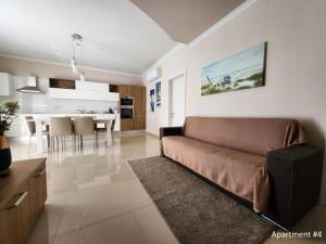 a living room with a couch and a kitchen at Riviera Holiday Apartments - Seafront - Wifi in Marsaskala