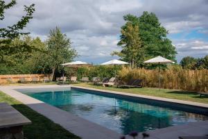 a swimming pool with chairs and umbrellas at Best Western Plus Metz Technopole in Metz