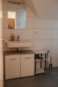 a bathroom with a sink and a mirror at Ferienwohnung Südblick in Barntrup +23 photos