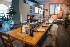 a long wooden table with candles on it in a living room at Jokimaja BoutiqueHotel in Köngäs